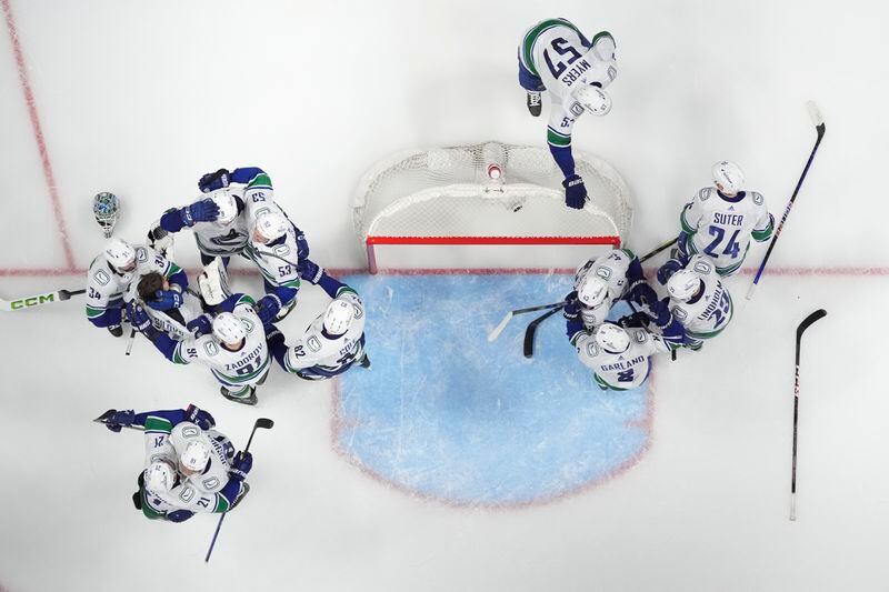 Vancouver Canucks players celebrate the team's 1-0 win against the Nashville Predators in Game 6 of an NHL hockey Stanley Cup first-round playoff series Friday, May 3, 2024, in Nashville, Tenn. The Canucks won the series four games to two. (AP Photo/George Walker IV)