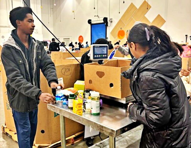 Southwest DeKalb sophomore Tristan Rudolph and freshman Madison Venable pack boxes at the Atlanta Community Food Bank.