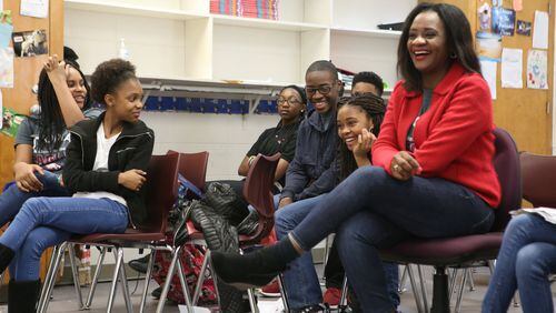 Tonia Jackson (red sweater) enjoys a light moment with students at the Utopian Academy for the Arts. The “Greenleaf” co-star has been teaching drama at the Clayton County charter school since August. HENRY TAYLOR / HENRY.TAYLOR@AJC.COM