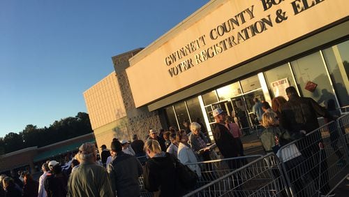 Hundreds of people lined up outside the Gwinnett County elections office Monday morning for the first day of early voting. TYLER ESTEP / TYLER.ESTEP@AJC.COM