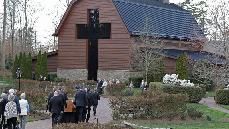 Pall bearers carry the casket with the body of Billy Graham in front of family members to the Billy Graham Library in Charlotte, N.C., Saturday, Feb. 24, 2018. Graham's body was brought to his hometown of Charlotte on Saturday, Feb. 24, as part of a procession expected to draw crowds of well-wishers. (AP Photo/Chuck Burton)