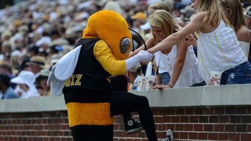 Georgia Tech fans help team mascot Buzz into the stands by fans during the first half of an NCAA college football game against Pittsburgh, Saturday, Sept. 23, 2017, in Atlanta. (AP Photo/Jon Barash)