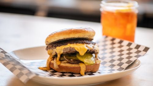 The Abby Singer Jucy Lucy is a half-pound of all-natural beef burger with molten American cheese, caramelized onions, and dill pickle chips. (Mia Yakel for The Atlanta Journal-Constitution)