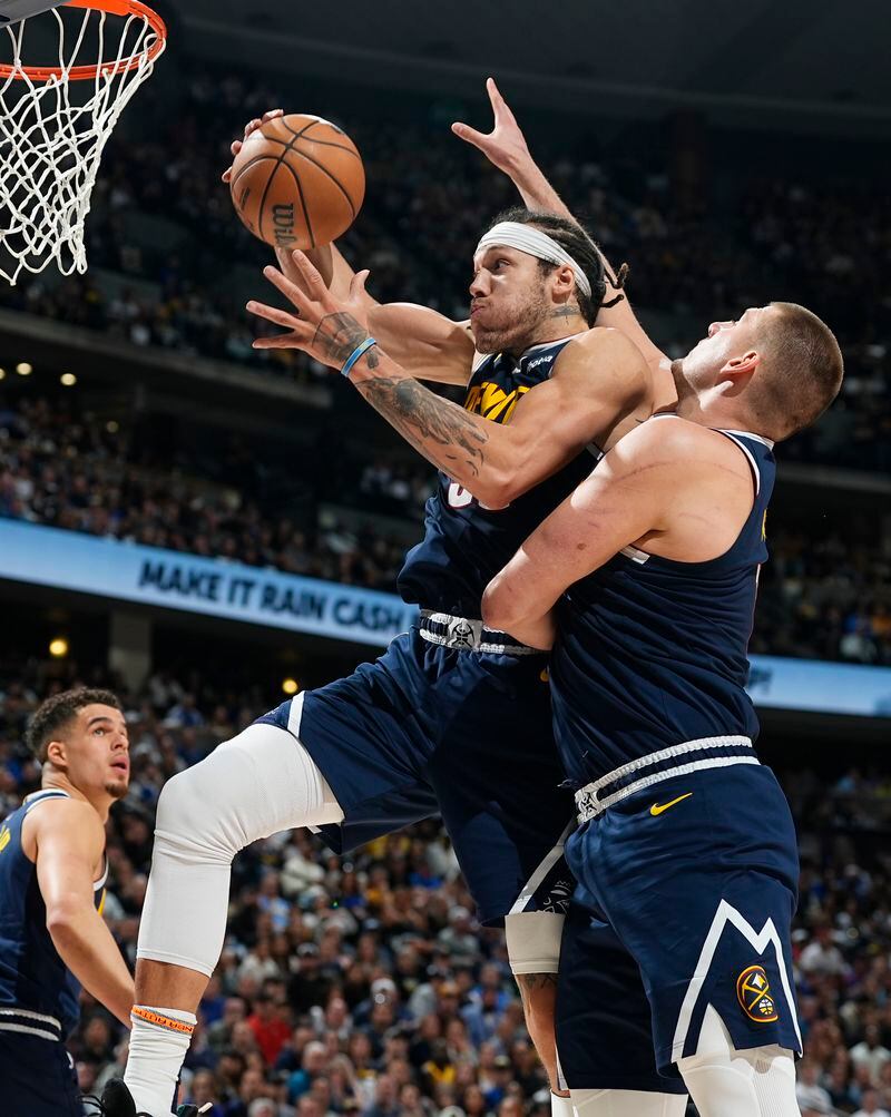Denver Nuggets forward Aaron Gordon, center, pulls in a rebound in front of center Nikola Jokic in the second half of Game 5 of an NBA basketball first-round playoff series against the Los Angeles Lakers Monday, April 29, 2024, in Denver. (AP Photo/David Zalubowski)