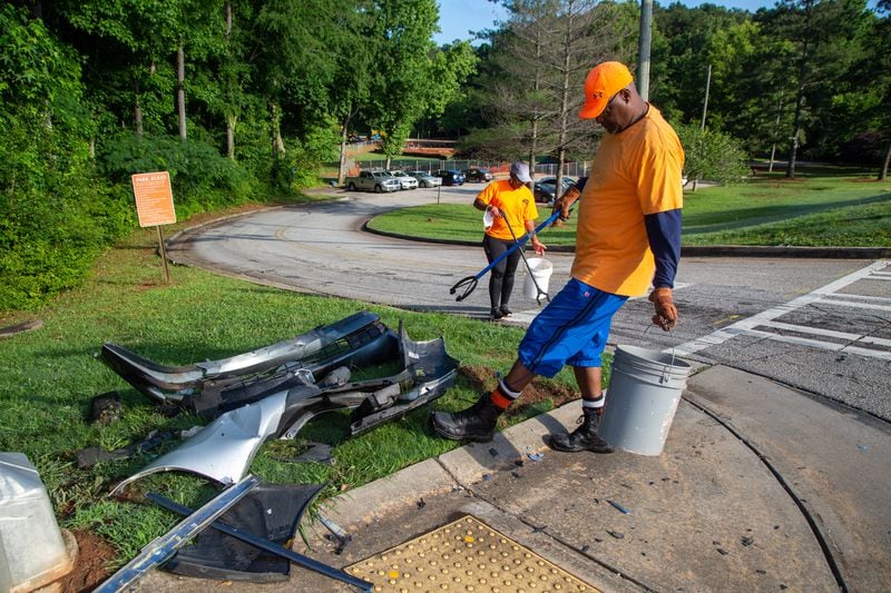 Karen Edwards (left) and Patrick Medley Sr. clean up debris from a car crash as they work with a group of his neighbors picking up trash at Hairston Park in Stone Mountain.  PHIL SKINNER FOR THE ATLANTA JOURNAL-CONSTITUTION.