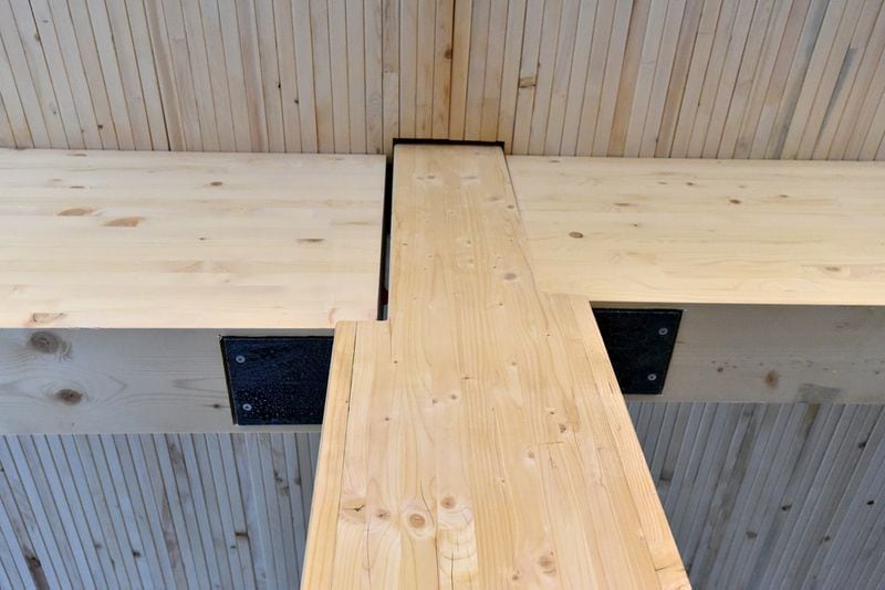 The floors above the first feature manufactured wood columns and beams braced by steel and as well as a flooring system that includes laminated 2-by-8-foot wood beams sandwiched with a layer of concrete.