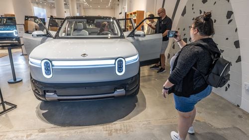 Sabrina Eijan takes a photograph of the new Rivian R2 prototype that will eventually be made in Georgia at the Ponce City Market in Atlanta on April 27, 2024.  (Steve Schaefer / AJC)