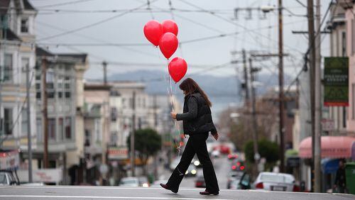 SAN FRANCISCO, CA - FEBRUARY 14: A woman carries a bunch of ballons as she walks down Union Street on Valentine's Day on February 14, 2011 in San Francisco, California. Valentine's Day is actually a Catholic church sanctioned holiday, as Pope Gelasius deemed February 14, St. Valentine's Day, near 498 A.D. (Photo by Justin Sullivan/Getty Images)