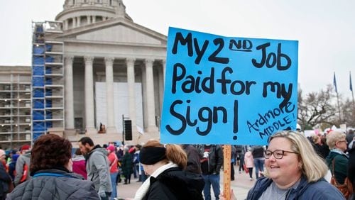 An Oklahoma teacher holds a sign as teachers rally against low school funding at the state Capitol in Oklahoma City in April. Teacher pay and school funding have become flashpoints in many states.
