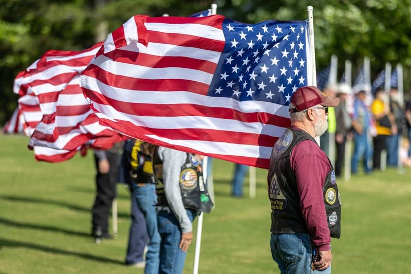 James Marshall stands with fellow Patriot Guards during the ceremony at the Georgia National Cemetery in Canton Saturday, May 27, 2023. Volunteers will place an estimated 21,000 flags at  tombstones during the ceremony (Steve Schaefer/steve.schaefer@ajc.com)