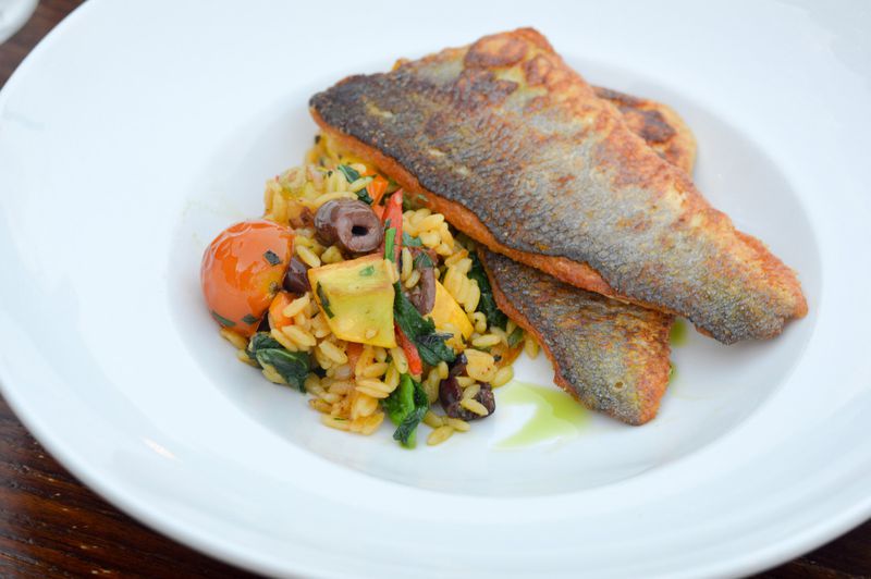 An entree of pan-roasted branzino is served with Mediterranean orzo at Mediterranea in Grant Park. CONTRIBUTED BY HENRI HOLLIS