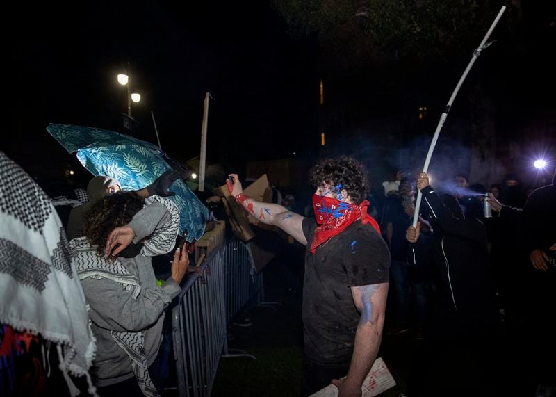 Demonstrators clash at a pro-Palestinian encampment at UCLA early Wednesday, May 1, 2024, in Los Angeles. Dueling groups of protesters have clashed at the University of California, Los Angeles, grappling in fistfights and shoving, kicking and using sticks to beat one another. (AP Photo/Ethan Swope)
