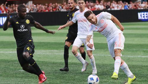August 19, 2018 Atlanta: Atlanta United midfielder Hector Villalba scores a goal past Columbus Crew defender Jonathan Mensah for a 2-1 lead during the second half in a MLS soccer match on Sunday, August 19, 2018, in Atlanta.  Curtis Compton/ccompton@ajc.com