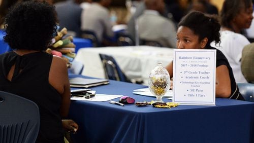 At a DeKalb Schools job fair last year, a candidate talks with a representative of Rainbow Elementary. The district is holding a job fair Dec. 7 at DeKalb Early College Academy in Stone Mountain.
