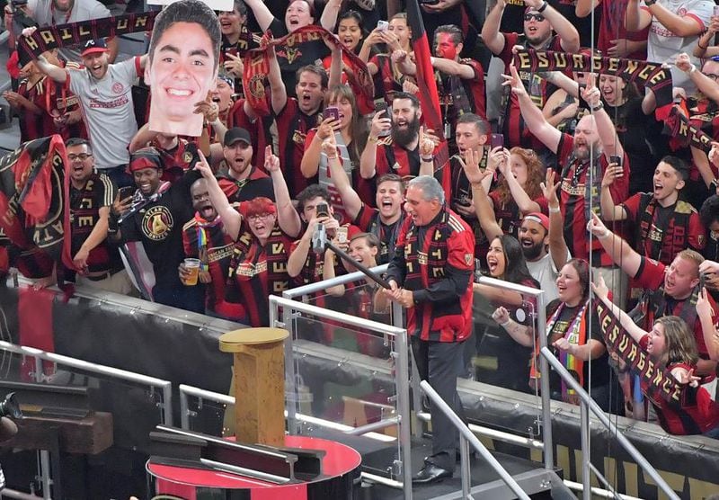 Arthur Blank, owner of Atlanta United FC, hammers in Atlanta United's golden spike in front of record-breaking crowd before an MLS soccer game last season. The golden spike tradition references the moment that surveyors set the railroad terminus in 1837 that would become Atlanta. Today, the Zero Mile Post marks that historic terminus. (HYOSUB SHIN / AJC)