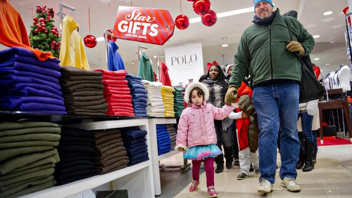 Ken Feinberg (right) holds his daughter Anauka's hand as they walk through Macy's at Lenox Square mall in Atlanta after doors opened for a previous Black Friday. JONATHAN PHILLIPS / SPECIAL