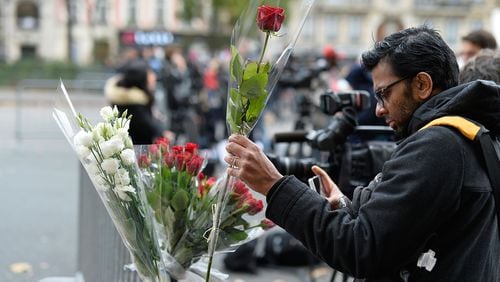 PARIS, FRANCE - NOVEMBER 14: A man places a floral tribute near the scene of the Bataclan Theatre terrorist attack on November 14, 2015 in Paris, France. At least 120 people have been killed and over 200 injured, 80 of which seriously, following a series of terrorist attacks in the French capital. (Photo by Pascal Le Segretain/Getty Images)