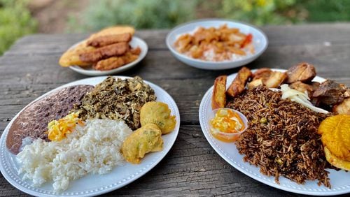 This takeout order from Jojo Fritay includes (left) lalo with white rice, black beans, pikliz and marinad; and (right) griot with fried plantains, mushroom rice, fried sweet potatoes and pikliz. In the background, a selection of fritay and conk stew. Wendell Brock for The AJC