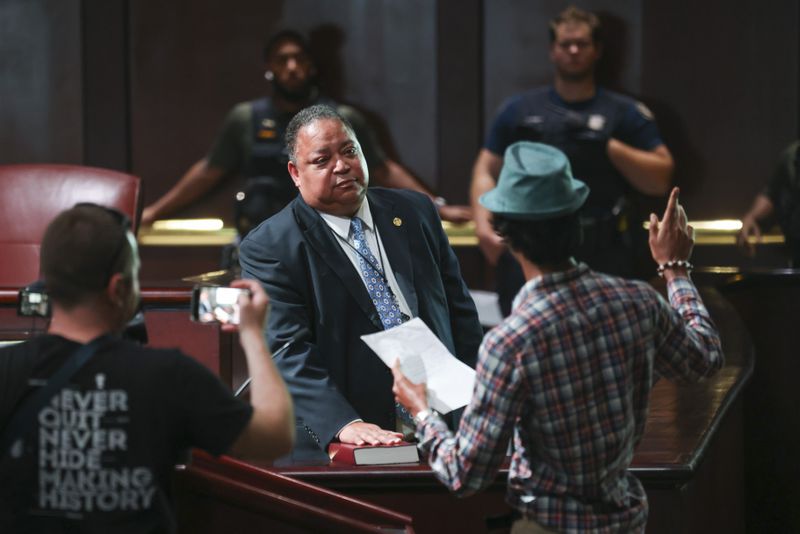Council member Michael Julian Bond puts his hand on a bible as directed by a protestor during the public comment portion ahead of the final vote to approve legislation to fund the training center, on Monday, June 5, 2023, in Atlanta. (Jason Getz / Jason.Getz@ajc.com)