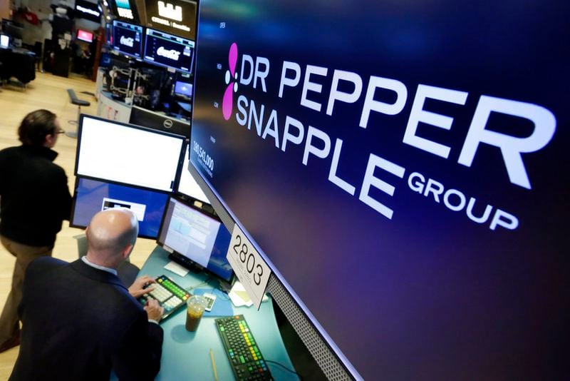 The Dr. Pepper Snapple Group logo appears above a trading post on the floor of the New York Stock Exchange, Monday, Jan. 29, 2018. Keurig is buying Dr. Pepper Snapple Group Inc., creating a beverage giant with about $11 billion in annual sales. (AP Photo/Richard Drew)