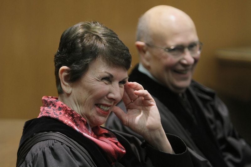 Justice Carol Huntstein (left) and Justice George Carley share a moment of laughter when Carley was sworn in as the 29th Chief Justice of the Supreme Court of Georgia in 2012. Hunstein had stepped aside as chief justice to allow Carley to be chief before he retired from the bench. VINO WONG / VWONG@AJC.COM  

