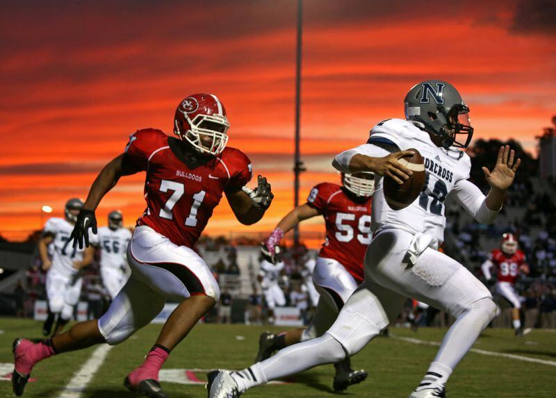 October 3, 2014 - Suwanee, Ga: The sun sets as Norcross quarterback Jacob Gassert (12) scrambles for yards against North Gwinnett defensive lineman Anree Saint-Amour (71) in the first half of their game Friday in Suwanee, Ga., October 3, 2014. JASON GETZ / SPECIAL Georgia Tech commit Anree Saint-Amour, a defensive end at North Gwinnett High, selected Tech over Stanford, Michigan State and Kentucky, among others. His selection, among others, bodes well for the Yellow Jackets’ signing class. Beautiful picture, isn’t it? (AJC file photo by Jason Getz)