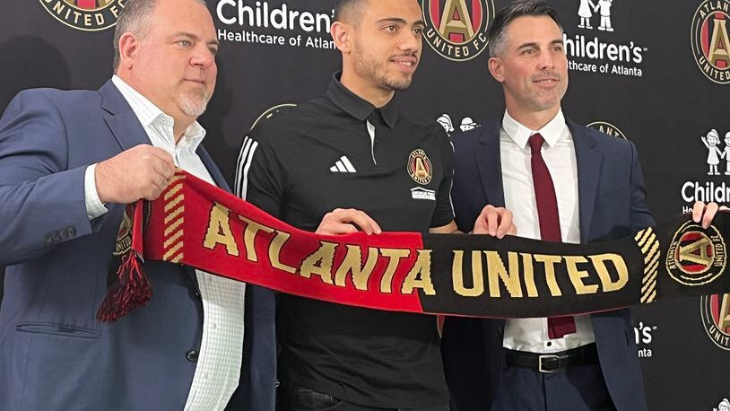 Atlanta United President Garth Lagerwey, Giorgos Giakoumakis and Vice President Carlos Bocanegra pose on Friday at the introduction of the player. (Doug Roberson/The Atlanta Journal-Constitution)