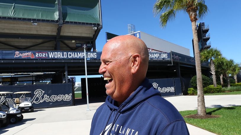 Braves manager Brian Snitker shares a laugh as he arrives for his press conference the day players have to report for spring training at CoolToday Park on Sunday, March 13, 2022, in North Port. The team’s first official workout is scheduled for Monday.   “Curtis Compton / Curtis.Compton@ajc.com”`