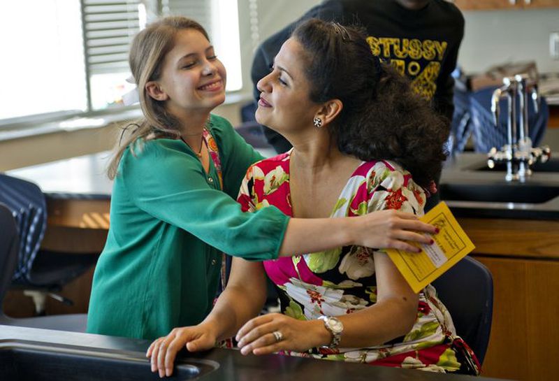 Shaheen Begum (right), a science teacher at Chamblee High School, gets a hug from one of her students Sarah Wright as she heads off to class on Monday, Nov. 10, 2014. Georgia school systems have spent at least $52.5 million over the past five years importing teaches from other countries, primarily India, to fill positions teaching math, science and special education — areas where there are shortage of domestic teachers. To get the teachers, the districts go through recruiting firms that sponsor the immigrants’ special H-1B visas, the largest of which is Morrow-based Global Teachers Research and Resources. Global already has been cited by the U.S. Labor Department for forcing teachers to pay fees the company should pay. JONATHAN PHILLIPS / SPECIAL