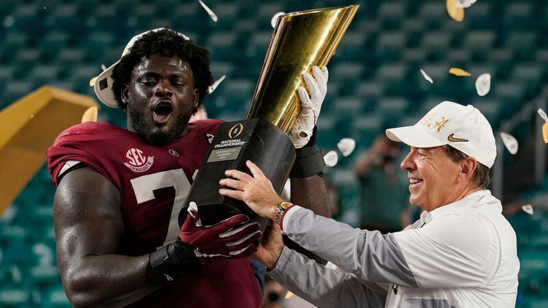 Alabama head coach Nick Saban and offensive lineman Alex Leatherwood hold the trophy after their win against Ohio State in the College Football Playoff championship game, Tuesday, Jan. 12, 2021, in Miami Gardens, Fla. Alabama won 52-24. (Lynne Sladky/AP)