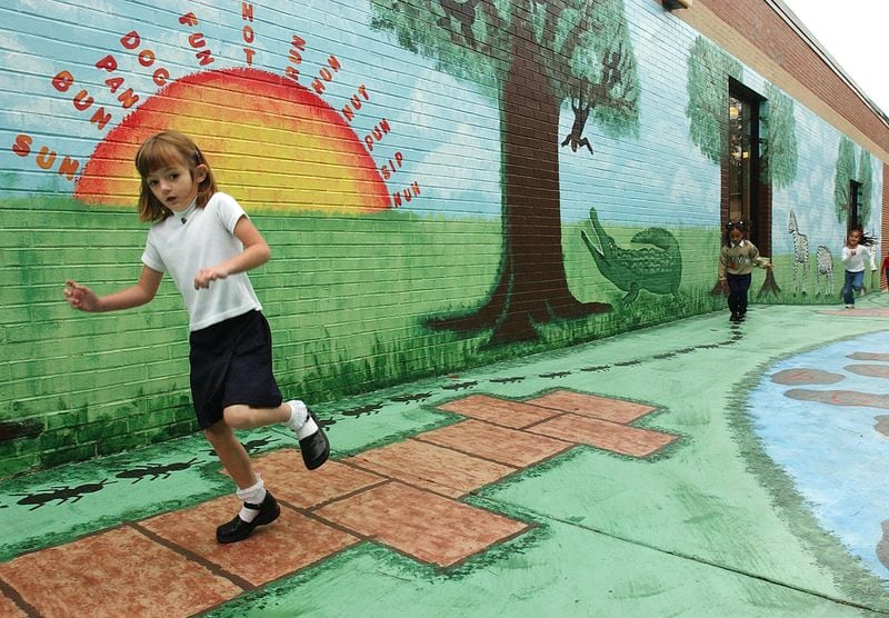 This Oct. 23, 2002 photo was taken at Marietta's Park Street Elementary School. Kindergartener Leslie Paige, 5 at the time, was playing on an alleyway mural painted over two summers by Park Street teachers. (Andy Sharp)