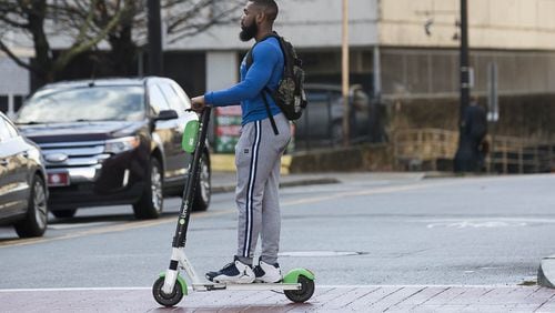 01/04/2019 — Atlanta, Georgia — A man rides a Lime Scooter on Peachtree Street in Atlanta’s Midtown community, Friday, January 4, 2019. (ALYSSA POINTER/ALYSSA.POINTER@AJC.COM)