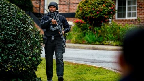 An Atlanta police officer surveys the situation at the scene of a SWAT standoff at the Fairburn Townhouses on Friday.