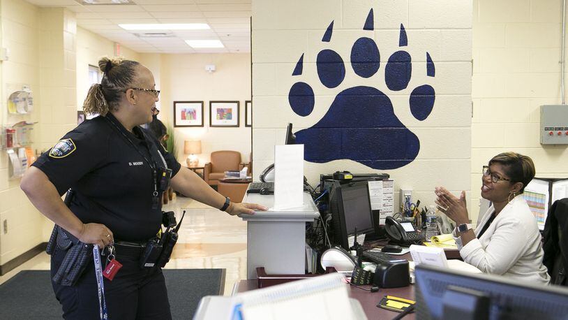 Officer Diane Moody (left) chats with Barnwell Elementary professional assistant Niki McKenzie at the front desk of Barnwell Elementary School in Johns Creek on Sept. 20, 2018. Newly released federal school safety guidelines call for training for school personnel, which is similar to recommendations released last month by the state Senate School Safety Study Committee. CASEY SYKES / CASEY.SYKES@AJC.COM