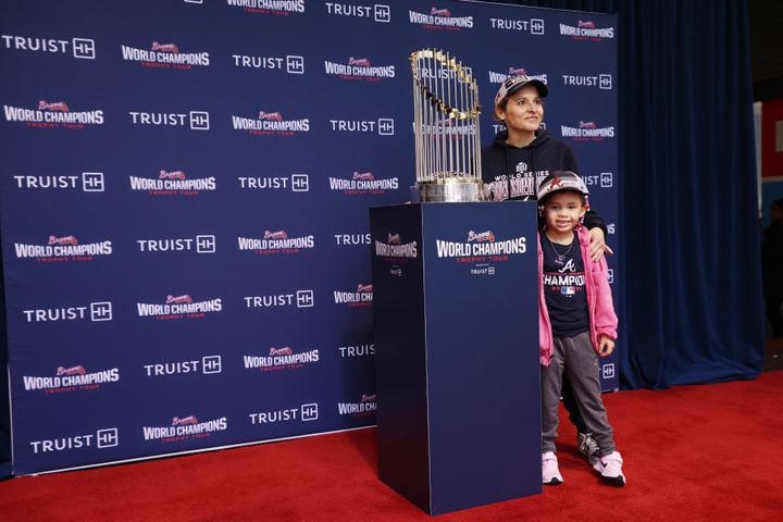 Jamie Gingold and her daughter Eleonora stand beside the Atlanta Braves World Champions Trophy. Miguel Martinez for The Atlanta Journal-Constitution 