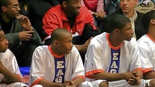 Kobe Bryant (in red) sits behind the Columbia boys basketball bench during a game Feb. 5, 2007. To Bryant's left is Rob Pelinka, his agent at the time, now  general manager of the Lakers. The Columbia players (from left) are Allen Moorer, Steve Lattimore and Antonio Wilson. Photo: DeKalb County Athletics