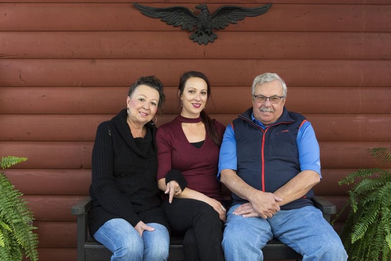 Mary Bernier (from left), daughter Emily and Mary’s husband, Robert, pose for a portrait outside their home in Blairsville, Ga., on Nov. 16, 2016. Bernier is the last surviving founder of the Georgia Ovarian Cancer Alliance. She, along with 12 other women who were diagnosed with ovarian cancer, formed an alliance to raise awareness about ovarian cancer and to help other women who have been diagnosed. DAVID BARNES / DAVID.BARNES@AJC.COM