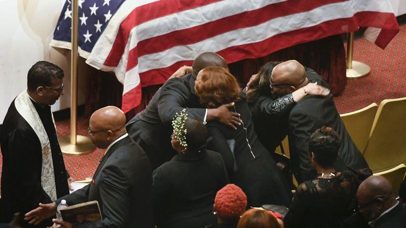 Family members are hugged by clergy during Saturday’s memorial service for CDC researcher Timothy Cunningham, who was pulled from the Chattahoochee River several weeks after he was reported missing. (John Amis / Contributed)