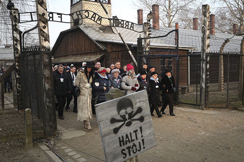 Poland's President Andrzej Duda walks Monday with survivors through the gates of the Auschwitz Nazi concentration camp  in Oswiecim, Poland.