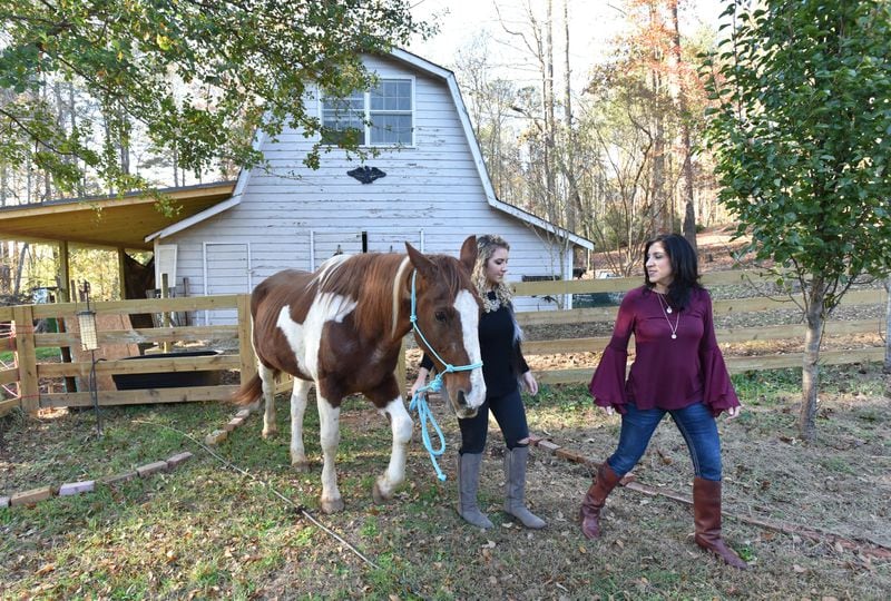 Dawn Camarda (right) and her daughter, Catherine Meier, bring out her horse at their home in Alpharetta. HYOSUB SHIN / HSHIN@AJC.COM