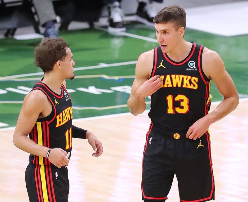 Hawks guards Trae Young (left) and Bogdan Bogdanovic confer as Bogdanovic reenters the game.   “Curtis Compton / Curtis.Compton@ajc.com”