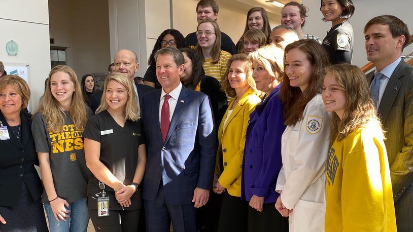 Georgia Gov. Brian Kemp (center in the front row) is joined by some Kennesaw State University students and other officials after an announcement by Wellstar Health System that it is donating $8.7 to the university's nursing program. ERIC STIRGUS/ESTIRGUS@AJC.COM