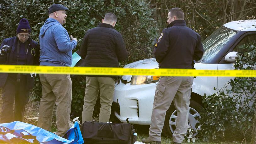 Investigators worked to learn who shot a man who crashed his SUV in the front yard of a Gwinnett County home Jan. 27. (John Spink / John.Spink@ajc.com)