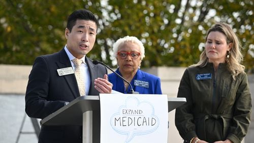 Rep. Sam Park, D-Lawrenceville, speaks as Sen. Gloria Butler, D-Stone Mountain (center) and Sen. Elena Parent, D-Atlanta, stand next to him during a press conference calling for full Medicaid expansion, after Gov. Brian Kemp's strict new Medicaid program "Pathways to Coverage" announced just 1,343 signups in its first three months.  At Liberty Plaza next to the Georgia State Capitol, Wednesday, October 25, 2023, in Atlanta. (Hyosub Shin/hyosub.shin@ajc.com)