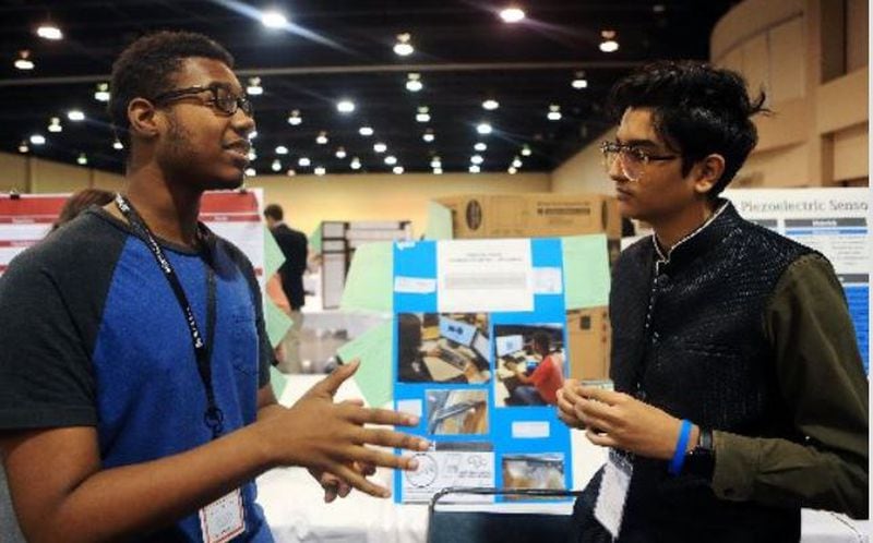 Quincy Sanders (left) and Jay Raval from Berkmar High School present their project on robotics and intelligent machines during Gwinnett’s science fair last month at the Infinite Energy Center in Duluth. CHRISTINA MATACOTTA for The Atlanta Journal-Constitution