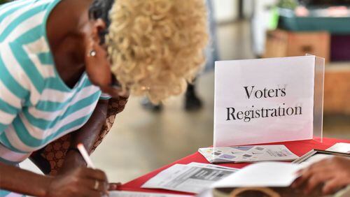 Sharon Huff of Atlanta fills in a voter registration form at a desk that the group Asian Americans Advancing Justice-Atlanta set up in The Sweet Auburn Curb Market in August. HYOSUB SHIN / HSHIN@AJC.COM
