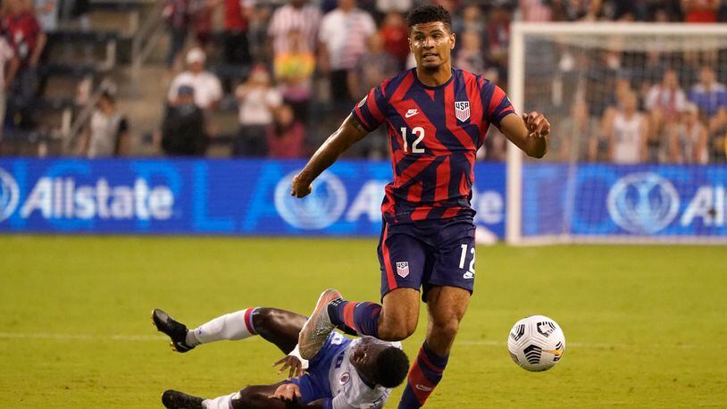 United States defender Miles Robinson (12) moves the ball past Haiti midfielder Derrick Ettiene Jr. (1o) during the first half of a CONCACAF Gold Cup soccer match Sunday, July 11, 2021, in Kansas City, Kan. (AP Photo/Charlie Riedel)