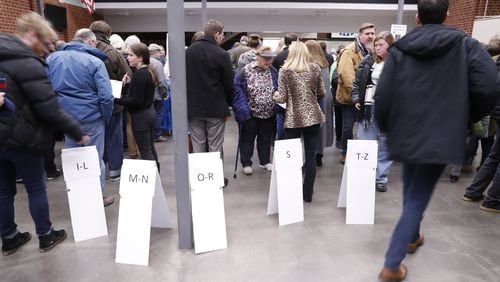 Signs guide caucus goers Monday as they arrive at Roosevelt High School in Des Moines, Iowa. (AP Photo/Andrew Harnik)