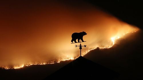 November 21, 2016, Clayton: At first glance the weathervane on the top of a barn appears to be a bear fleeing the Rock Mountain Fire as it burns across the top of ridge pole above Betty‰Û(TM)s Creek Road where home owners are under a pre-evacuation order as the fire approaches the area on Monday night, Nov. 21, 2016, just north of Clayton. Curtis Compton/ccompton@ajc.com