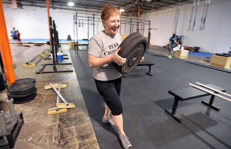 In this file photo, personal trainer Nancy Burnham prepares to lift weights at a CrossFit Burnham’s journey to health began at ge 61, when she stepped into a gym for the first time in her life. HYOSUB SHIN / HSHIN@AJC.COM
